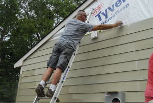 800px-U.S._Army_1st_Sgt._Benton_Gill_measures_the_length_of_the_house_before_he_installs_the_siding_in_Edinburgh,_Ind.,_Aug_110812-A-DX536-003