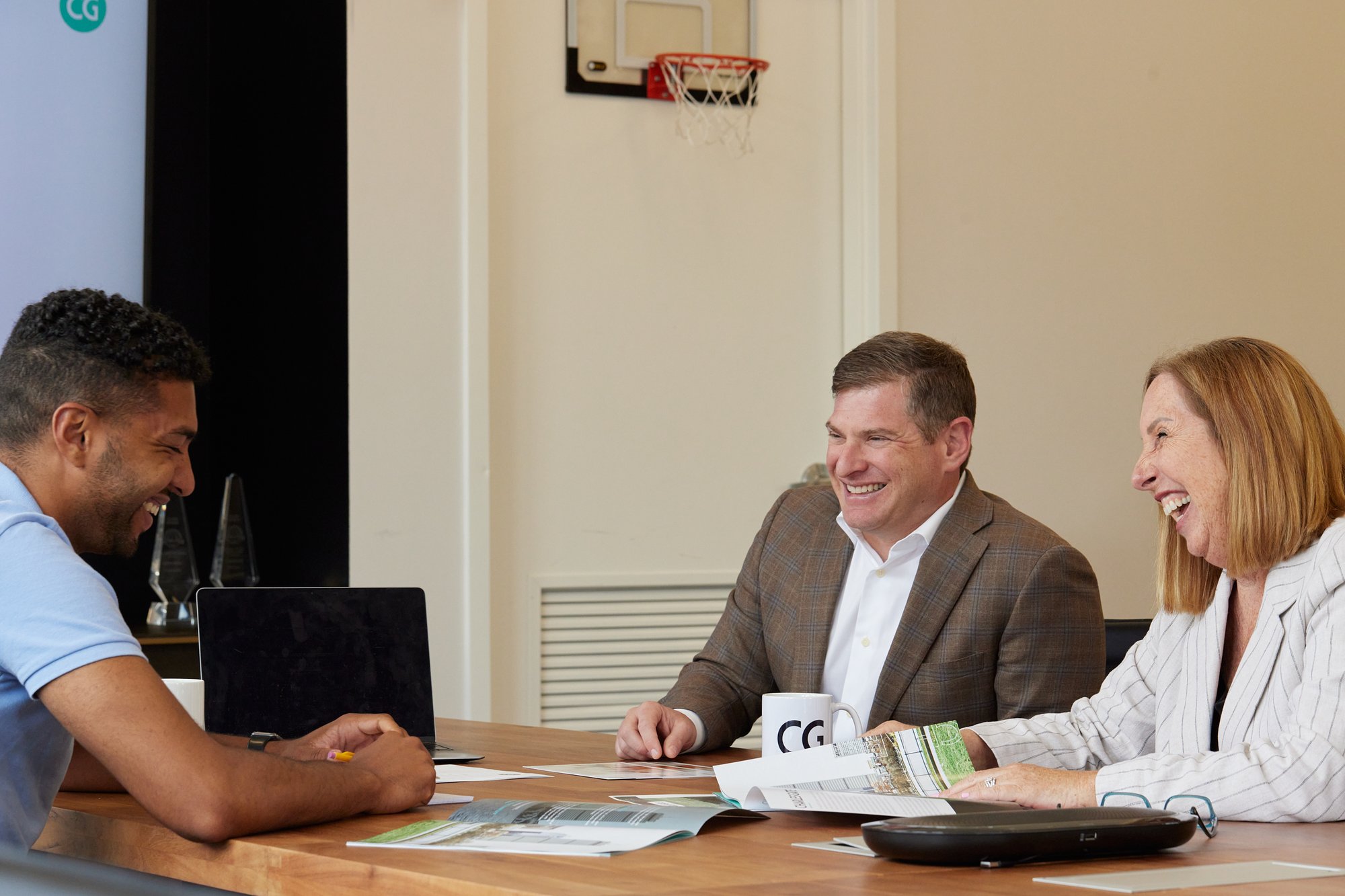 P.T. Vineburgh laughing at worktable with colleagues